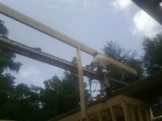 Carpenter setting a ridge beam over a new addition frame — Ice Dam Removal by Roofing Brothers in Forest Lakes