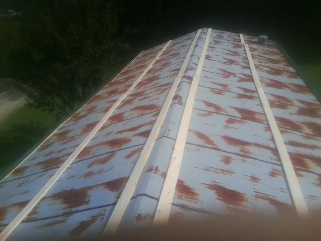 Rusted metal roof panels with new wood purlins before replacement — Storm Damage Roof Repair in Forest Lakes by Roofing Brothers