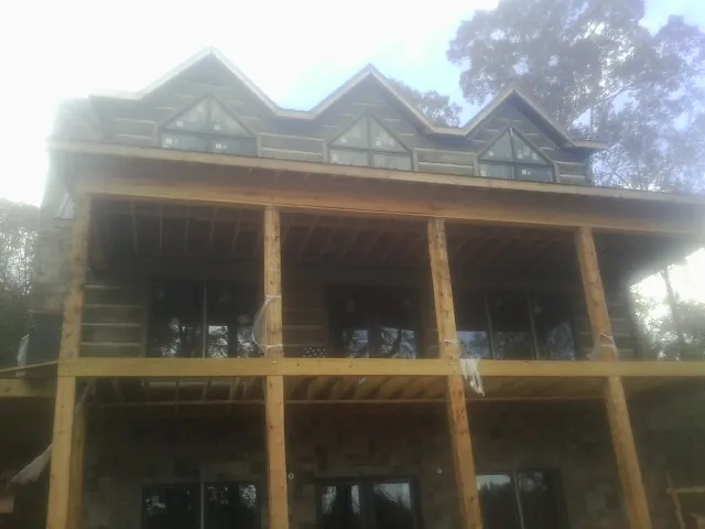 Dormers and porch framing on a large log home under construction — Roof Coating work by our crew in Forest Lakes